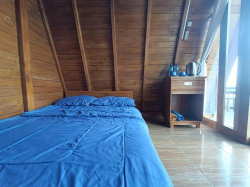 金塔马尼The Panorama Batur Camp的一间卧室设有蓝色的床和木墙