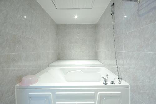 釜山WA酒店的浴室配有白色水槽和淋浴。