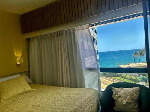 萨尔瓦多apart hotel 2 quartos frente mar的一间卧室配有一张床,享有海景