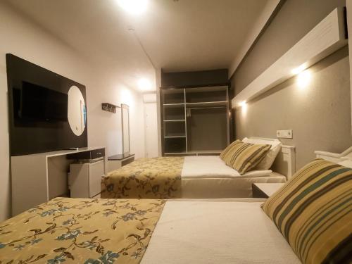 锡德SİDE SPRİNG HOTEL的酒店客房设有两张床和一台平面电视。
