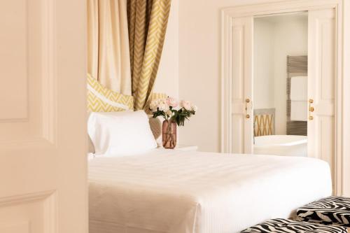 波尔图·埃尔科莱佩里卡诺酒店的卧室配有白色的床和花瓶