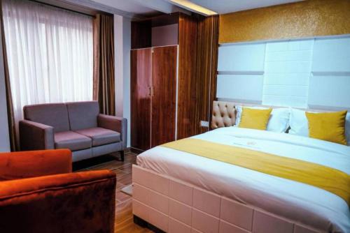 内罗毕Barre Hotel的一间卧室配有一张大床和一把椅子