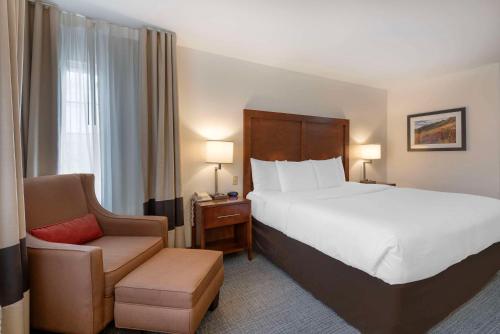 卡本代尔Comfort Inn & Suites Carbondale on the Roaring Fork的酒店客房带一张大床和一把椅子
