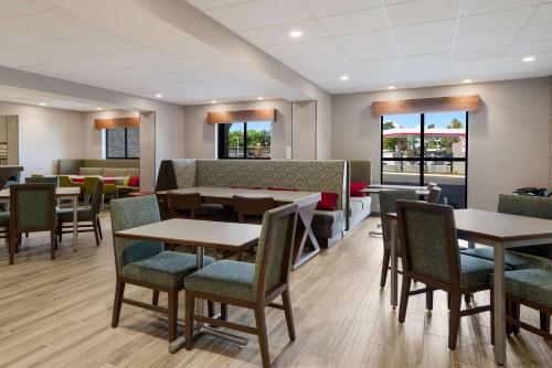 康科德Hampton Inn Concord的用餐室设有桌椅和窗户。