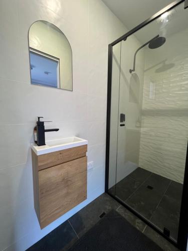 AdelongGold Reef Adelong的浴室配有盥洗盆和带镜子的淋浴
