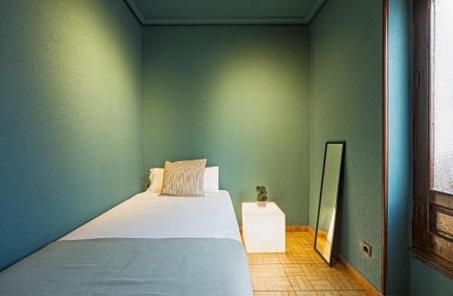 马德里Ideal Hostel Madrid的卧室设有一张位于绿色墙壁上的床铺