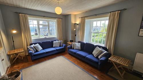 圣莫斯Corner Cottage的客厅配有2张蓝色沙发和2扇窗户