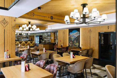 什恰夫尼察Hotel Maria & Spa的餐厅拥有木墙和桌椅