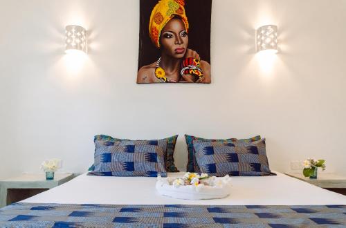 瓦塔穆Nyuso za Afrika的卧室配有一张带女性照片的床