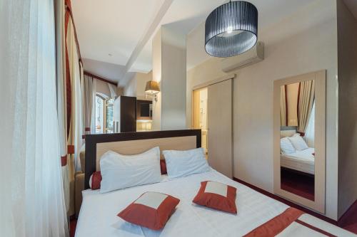 敖德萨皇家宫殿精品酒店 的一间卧室配有一张带两个枕头和镜子的床