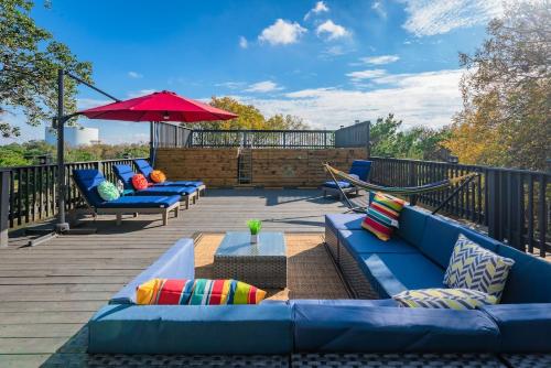 圣安东尼奥Breathtaking Roof Pool Views, Gameroom, Firepit的一个带蓝色沙发和红色遮阳伞的甲板