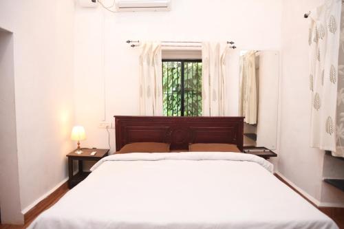 Moira4BHK Private Pool villa in North Goa and Kayaking nearby!!的白色的卧室设有床和窗户