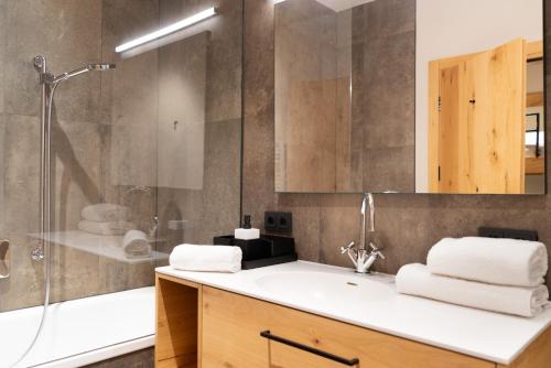 施勒肯Heimat 1495m Appartement TYP 3的带淋浴、盥洗盆和浴缸的浴室