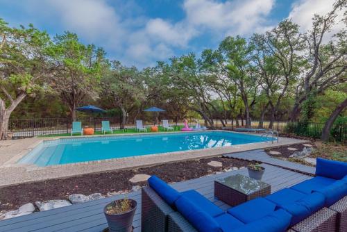 圣安东尼奥Luxury House By Fiesta Texas & Seaworld With Pool的一个带蓝色沙发和树木的游泳池