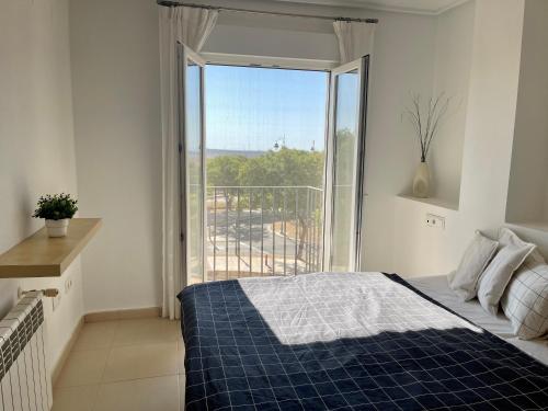 穆尔西亚Two bedroom Apt., Hacienda Riquelme Golf Resort的一间卧室设有一张床和一个大窗户