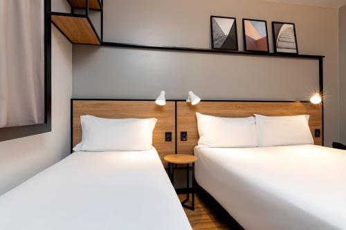 阿雷格里港阿雷格里港机场宜必思酒店的两张睡床彼此相邻,位于一个房间里