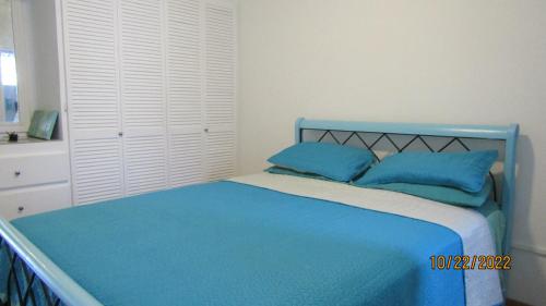 布里奇敦Cozy, quiet 1 bedroom 2A near Beach near US Embassy的卧室内的蓝色床和蓝色枕头