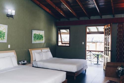 Bambitotierras altas casa grande的绿墙客房内的两张床