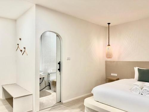 罗勇Sunvada Beach Rayong的一间白色卧室,配有床和一间浴室
