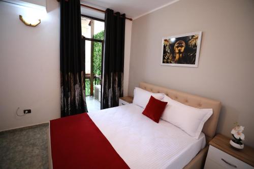 地拉那Little Corner Hostel的卧室配有白色和红色的床,设有窗户