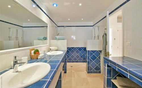 Saint-JeanSaint Barth Villa 1的浴室设有2个水槽,铺有蓝色瓷砖。