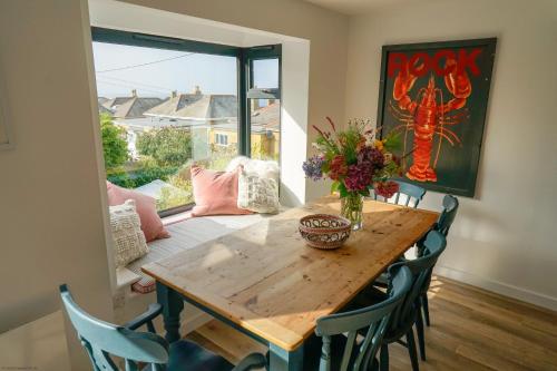 海景城Jumble Cottage的一间带木桌和椅子的用餐室