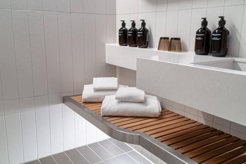 斯德哥尔摩北欧之光酒店的浴室设有黑瓶和架子上的毛巾