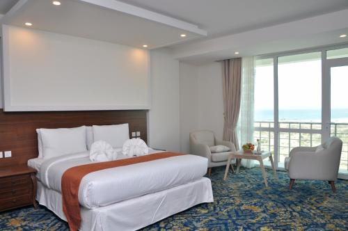苏尔Sur Grand Hotel的酒店客房设有一张床和一个大窗户