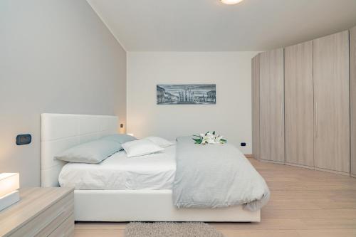 阿萨哥Milan Forum Camelia Guesthouse的白色卧室配有白色床和蓝色枕头