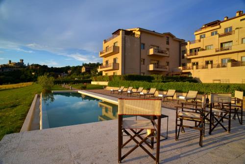 圣卡西亚诺·戴·巴格丰特利威酒店的一组椅子和一张桌子,旁边是游泳池