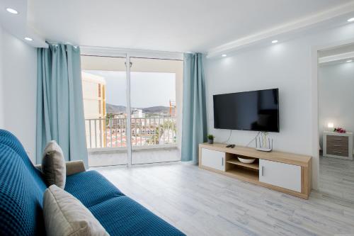 阿罗纳Fantastic Apartment las americas heart的客厅配有蓝色的沙发和电视