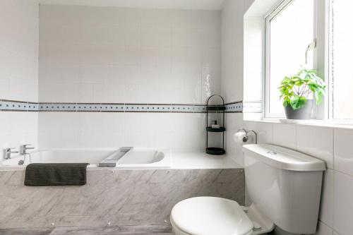 LincolnshireKime Contractor & Holiday Home的白色的浴室设有卫生间和浴缸。
