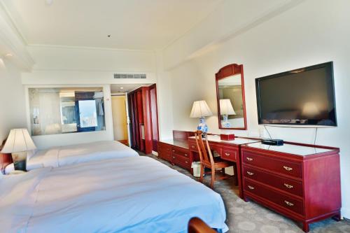 台中市T Hotel的酒店客房设有两张床和一台平面电视。