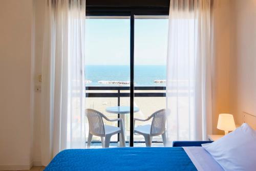 卡托利卡Rex Residence Hotel的一间卧室配有一张床,享有海景