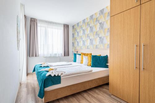 布达佩斯Nova Apartments的一间卧室配有两张带蓝色和黄色枕头的床