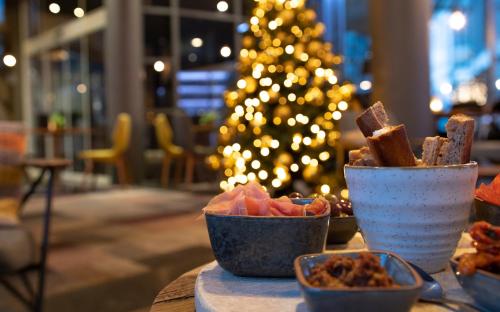 根特诺富特根特中心酒店的餐桌上放着一碗食物和一棵圣诞树