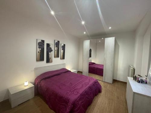 卡塞勒托瑞尼斯B&B L'Antico Portone的一间卧室配有一张紫色的床和镜子