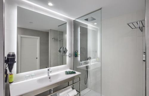 马拉加Sercotel Rosaleda Málaga的白色的浴室设有水槽和镜子