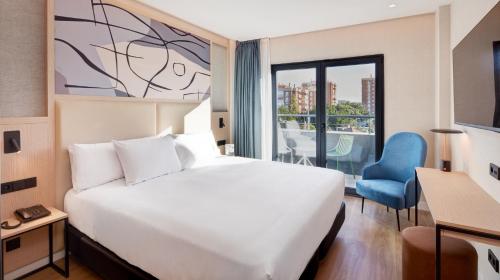 马拉加Sercotel Rosaleda Málaga的一间设有大床和窗户的酒店客房