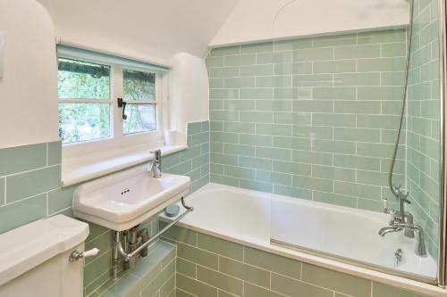 坎特伯雷Host & Stay - Bere Cottage的浴室配有盥洗盆和浴缸。
