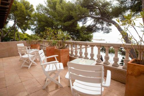 塔拉戈纳Paraíso Costa Dorada的俯瞰水面的庭院里摆放着几把椅子和桌子