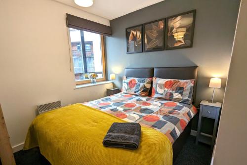 考文垂Gorgeous Modernised City Centre Apartment的一间卧室配有一张黄色棉被的床