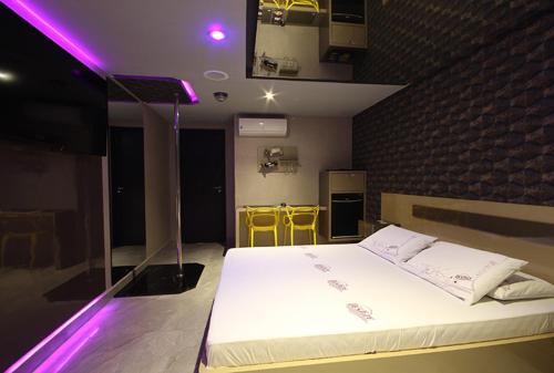 库里提巴Motel Deslize Curitiba的一间卧室配有一张紫色灯大床