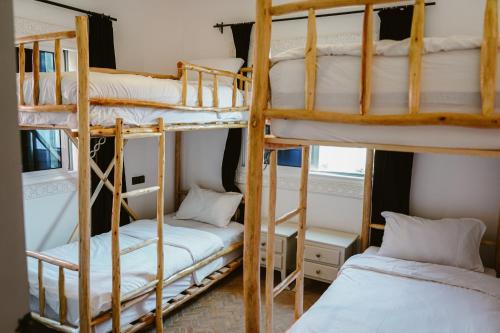 Tamraght Ou FellaDar Sultana Guesthouse Surf Morocco的带2张较小床的客房内的2张双层床