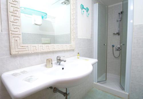 Casa dello StumioVillaggio Club Baia Dei Gigli的白色的浴室设有水槽和淋浴。