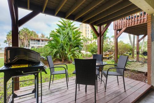 杰克逊维尔海滩Be A Nomad Beachside Apartments的一个带烧烤架、椅子和桌子的庭院