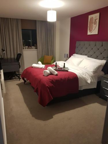 达德利Stunning 1-Bed Apartment in Brierley Hill的一间卧室配有一张带红色毯子的大床