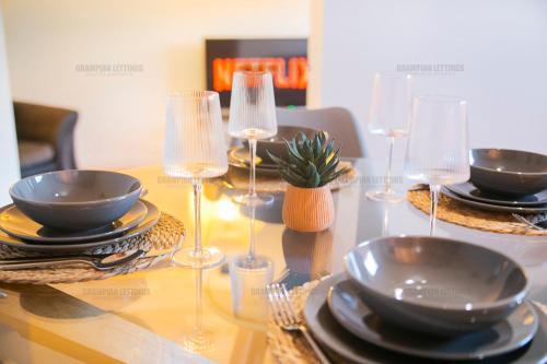 阿伯丁Riverside Drive Apartment - Grampian Lettings Ltd的一张桌子上放有盘子和酒杯