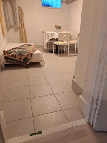 延雪平Lägenhet Huskvarna的客房铺有瓷砖地板,配有桌子和床。