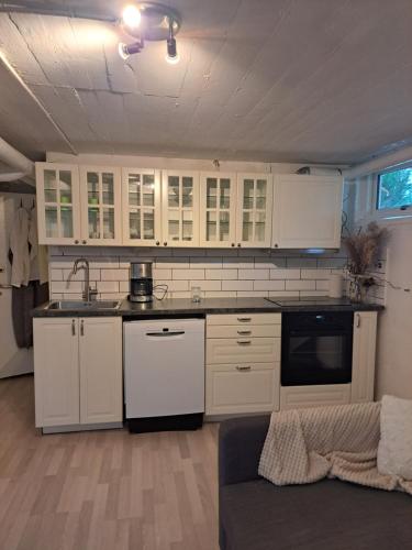 延雪平Lägenhet Huskvarna的一间厨房,内设白色橱柜和沙发